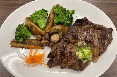 A plate of steak with vegetables.