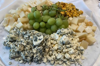 A platter of assorted cheeses and grapes