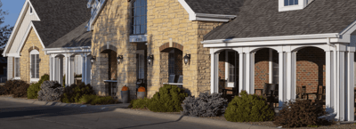Exterior view of a senior living facility with stone facade