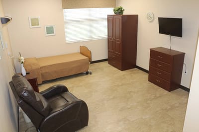Interior view of a private resident room with a bed and furniture