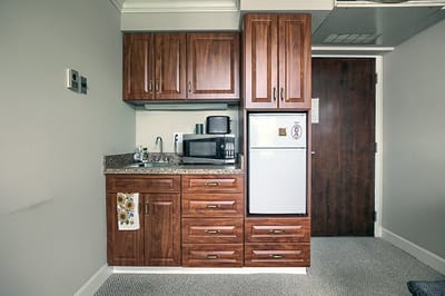 Interior kitchenette area with cabinets and appliances