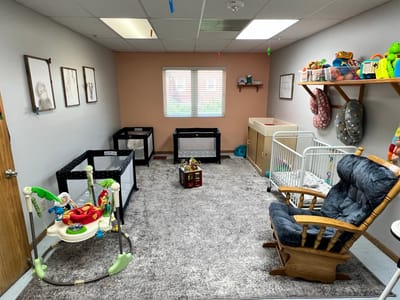Playroom with cribs and toys in a bright space