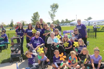 Residents and staff celebrating outdoors with flowers