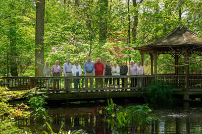Residents posing on a bridge in a garden