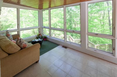 Bright sunroom with views of greenery outside.
