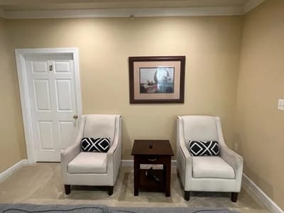 Cozy seating area with two chairs and a table.