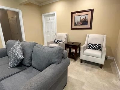 Comfortable seating area with two chairs and a couch.