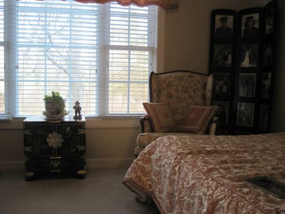 Cozy bedroom with floral decor and family photos.