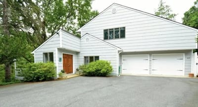 Exterior view of a white building surrounded by greenery.