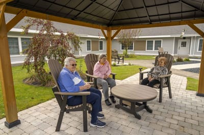 Residents enjoying time outdoors under a gazebo.