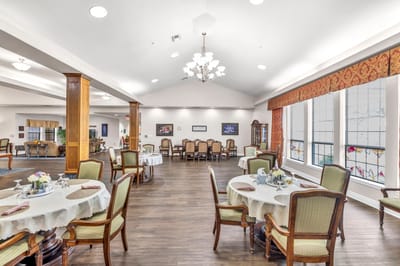 Dining area with tables and chairs set for meals.