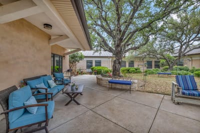 Outdoor seating area with greenery and trees.