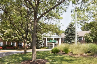 Front view of The Grove at Oakleaf Village with trees and garden