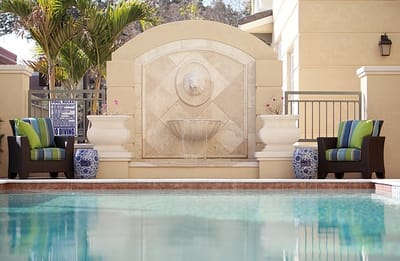 Decorative outdoor fountain and seating area by the pool