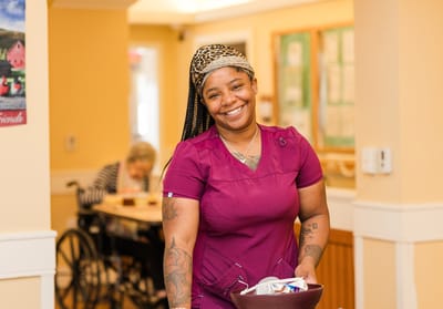 Staff member smiling in a facility hallway