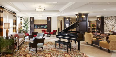 Alden Meadow Park Health Care Center, Inc, Nursing Home in Clinton, WI — Elegant common area with piano and seating arrangements