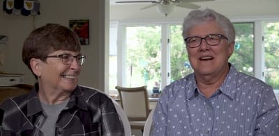 Two smiling residents in a bright common area