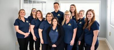 Staff members posing together in a bright room