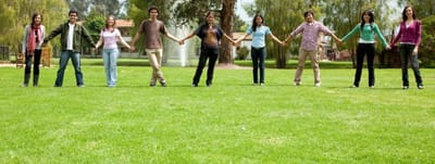 Group of young adults holding hands in a park