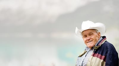 Smiling senior man wearing a cowboy hat outdoors