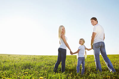 Family walking in a sunny green field