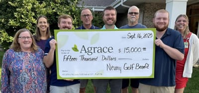 Group photo holding a large check for charity