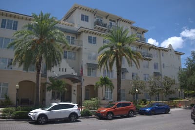 Exterior view of a senior living facility with palm trees