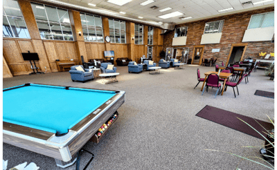 A spacious common area with seating and a pool table