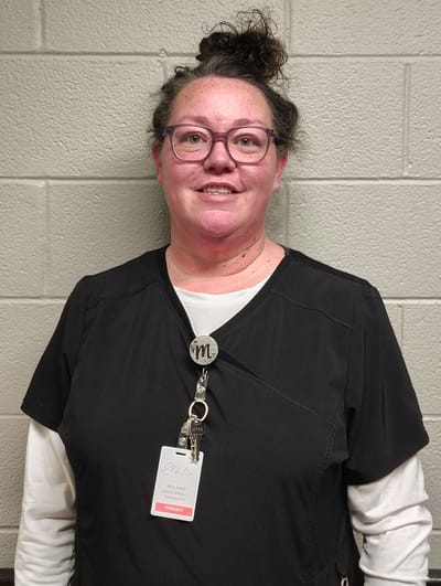 Staff member in scrubs with name badge