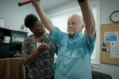 Staff assisting a resident with exercise.