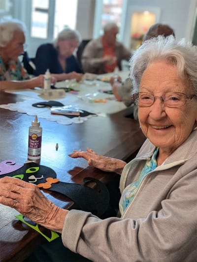 Elderly residents engaged in a craft activity.