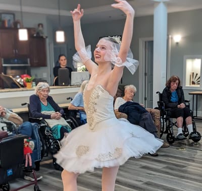 Ballet dancer performing for seated residents.