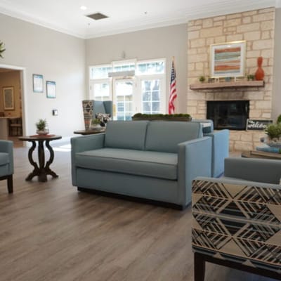 Bright and inviting common area with couches and fireplace.
