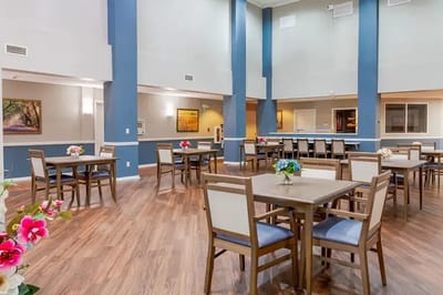 Bright dining room with tables and flowers
