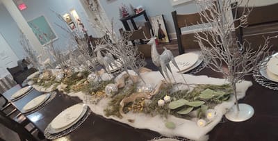Festively decorated dining table with silver trees.