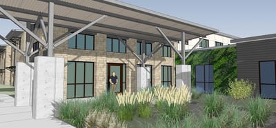 Front entrance of assisted living facility with person and landscaping.