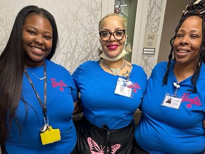 Three staff members smiling in uniforms