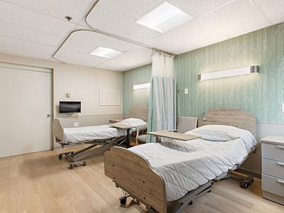 Shared resident room with two beds and a television.