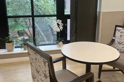 Common area with a table and chairs beside a window.