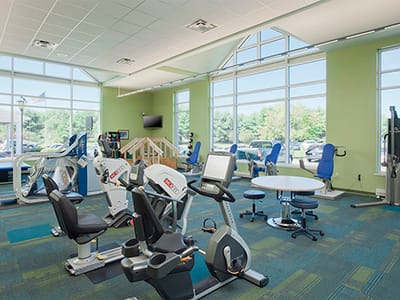 Fitness center with exercise equipment and large windows