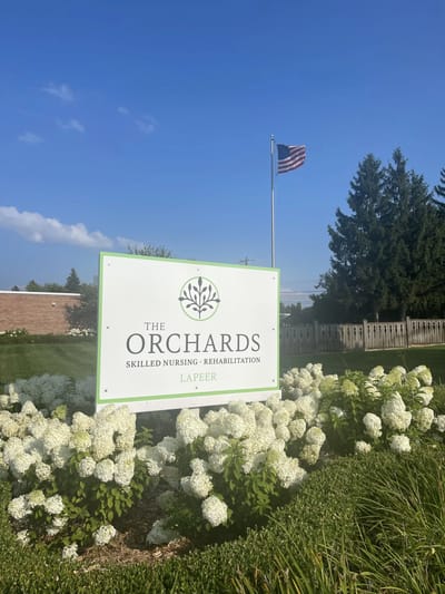 The Orchards facility sign with flowers in front
