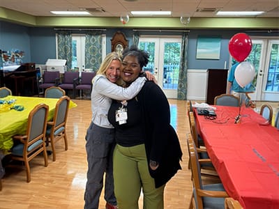 Two staff members celebrating in a community room
