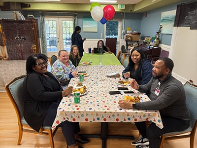 Residents and staff enjoying a meal together.