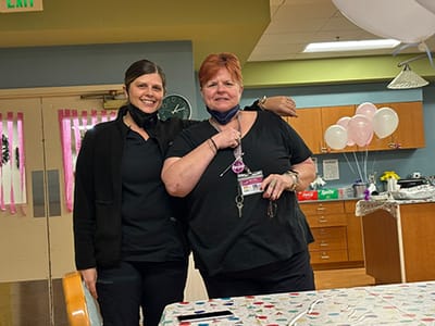Two staff members posing in a common area.