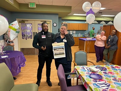 Residents and staff celebrating with balloons and decorations.