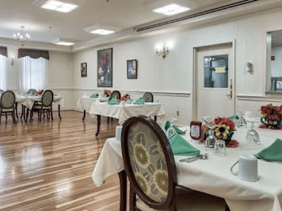 Dining area with neatly set tables and floral decorations.