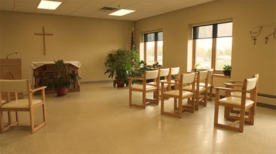 Interior view of a common area with chairs and plants.