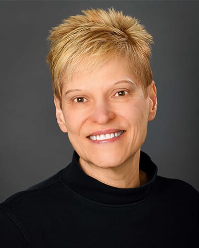 Smiling woman with short blonde hair.
