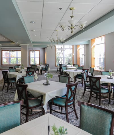 Well-lit dining room with tables and chairs