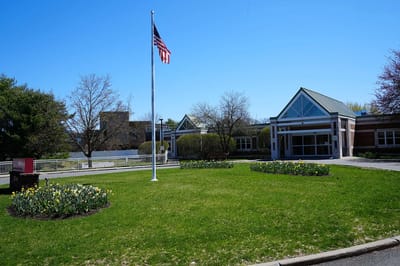 Exterior view of the nursing home with garden and flag